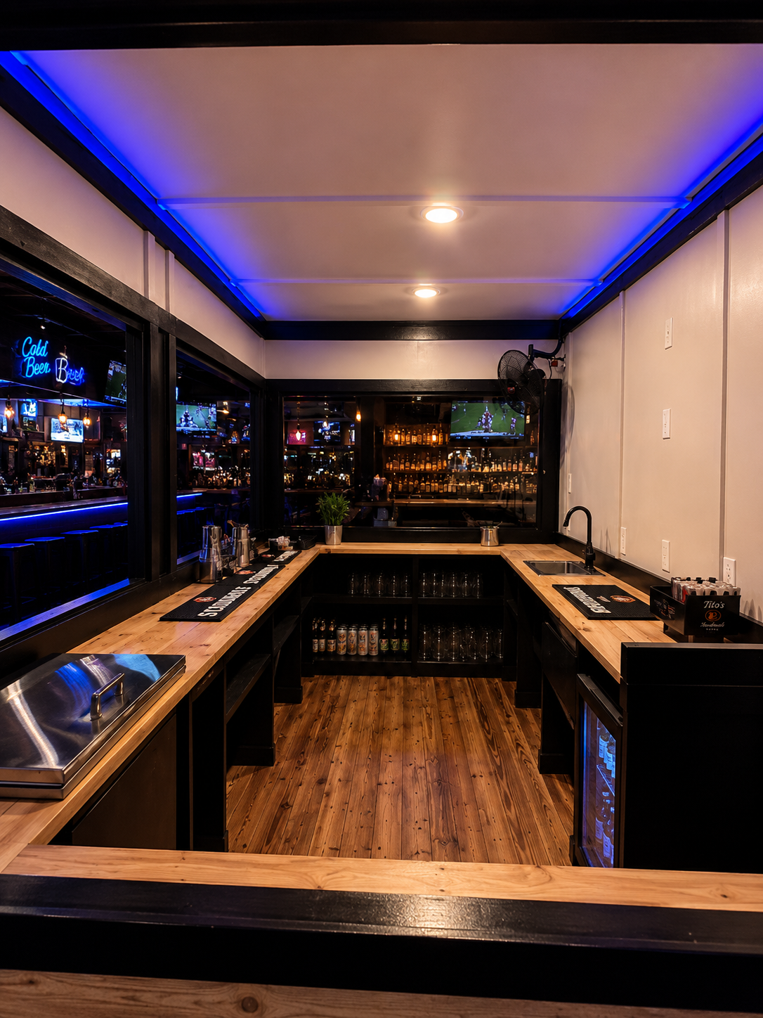 Custom container bar build with blue accent lighting and wood counters